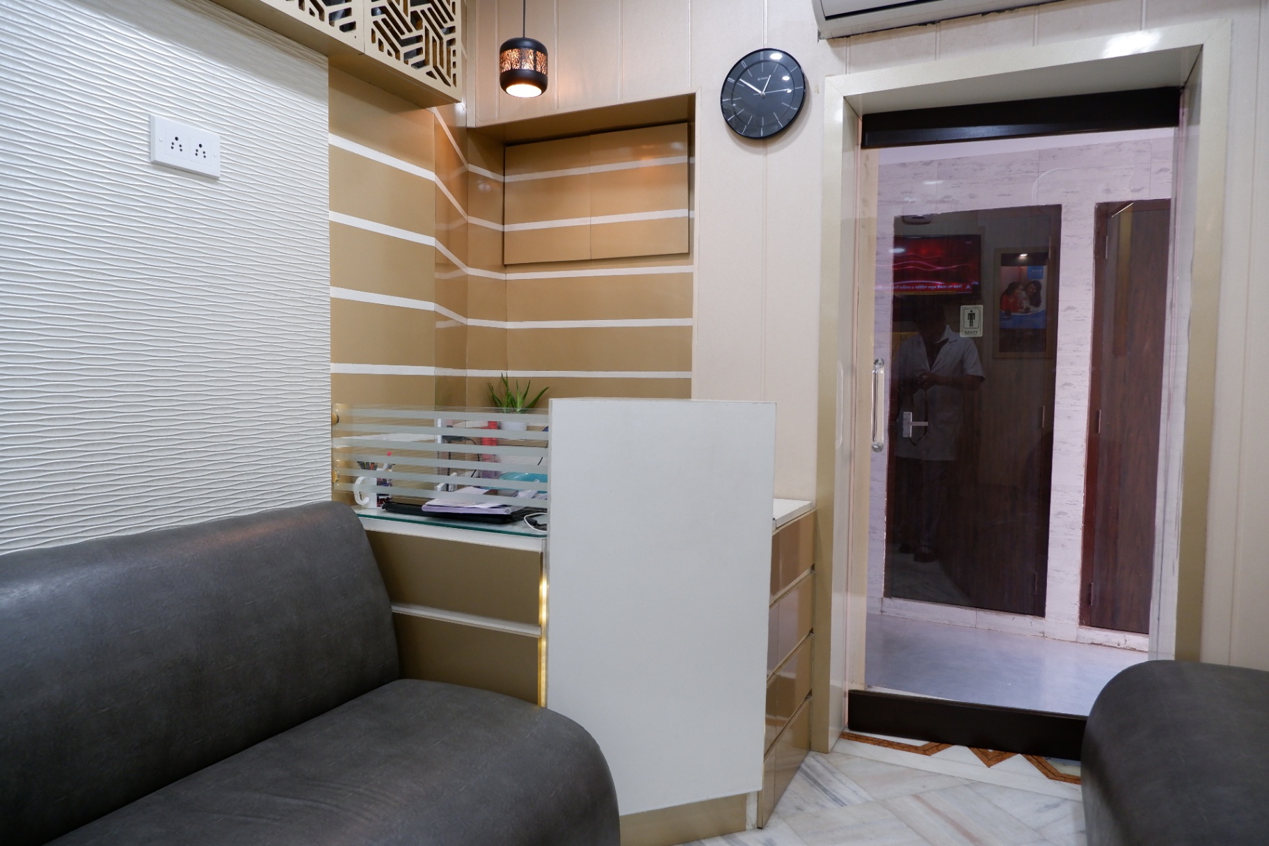 Reception desk with sofa seating at OroCare Dental Clinic, Bhowanipur