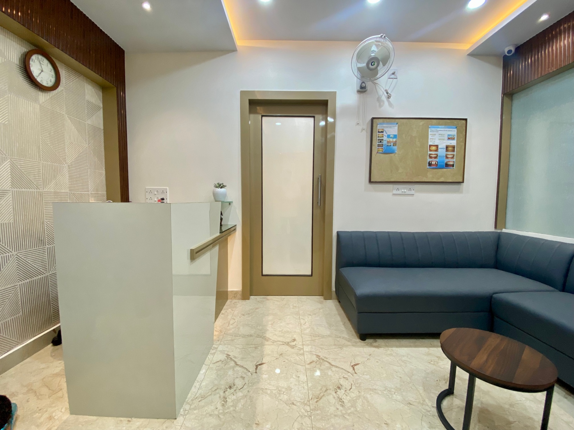Reception counter with patient seating and restroom access at OroCare Dental Clinic, Mukundapur
