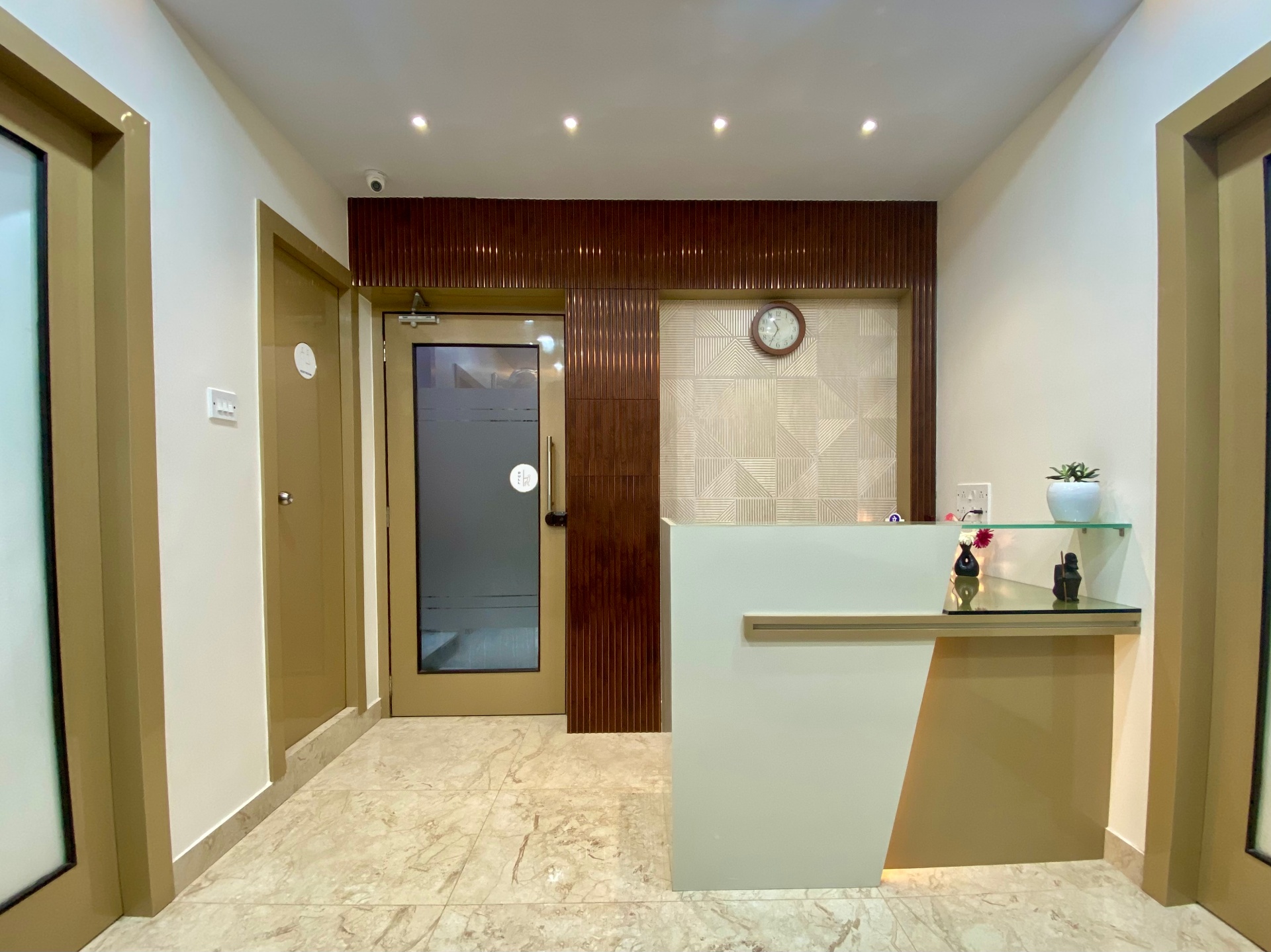 Reception desk and entrance with wood panelling at OroCare Dental Clinic, Mukundapur